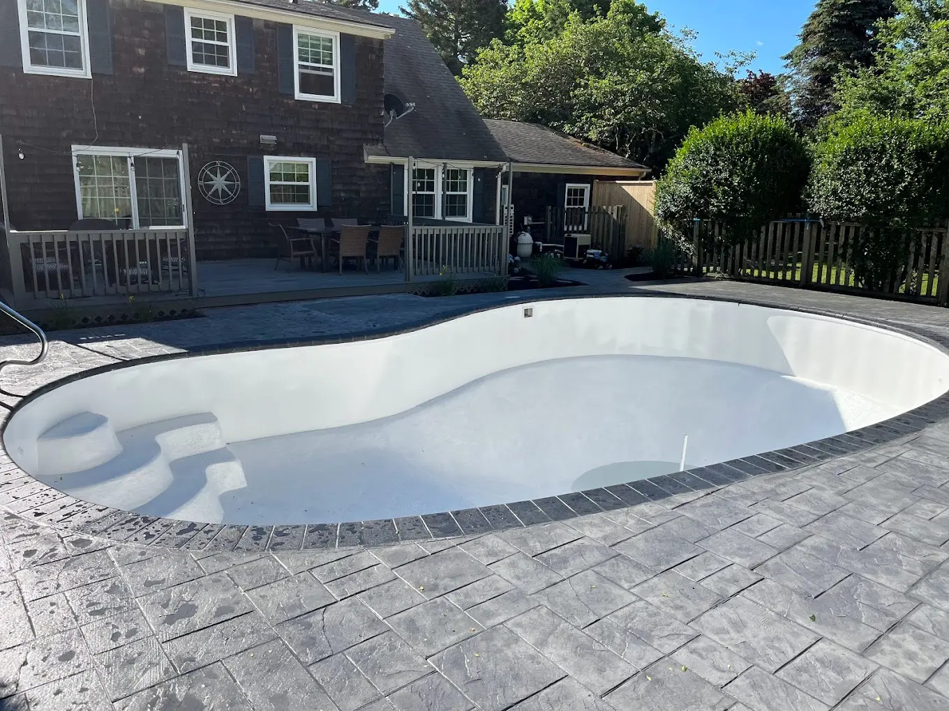 Stamped concrete pool deck surrounding a residential swimming pool.